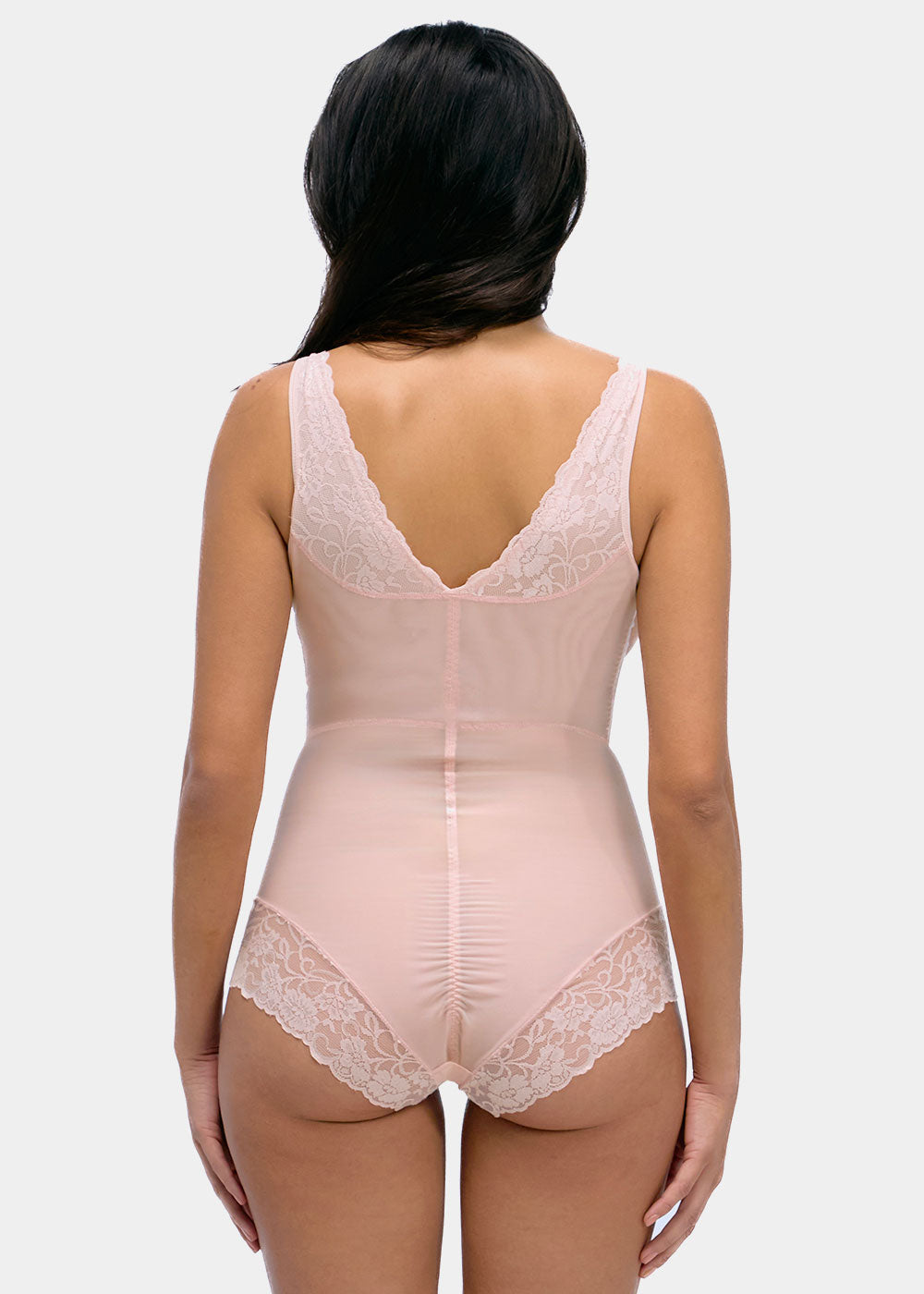 Woman wearing a beige bodysuit with lace details on a white background