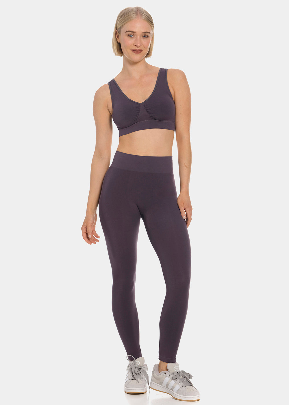Woman wearing a purple sports bra and Bamboo Legging on a white background